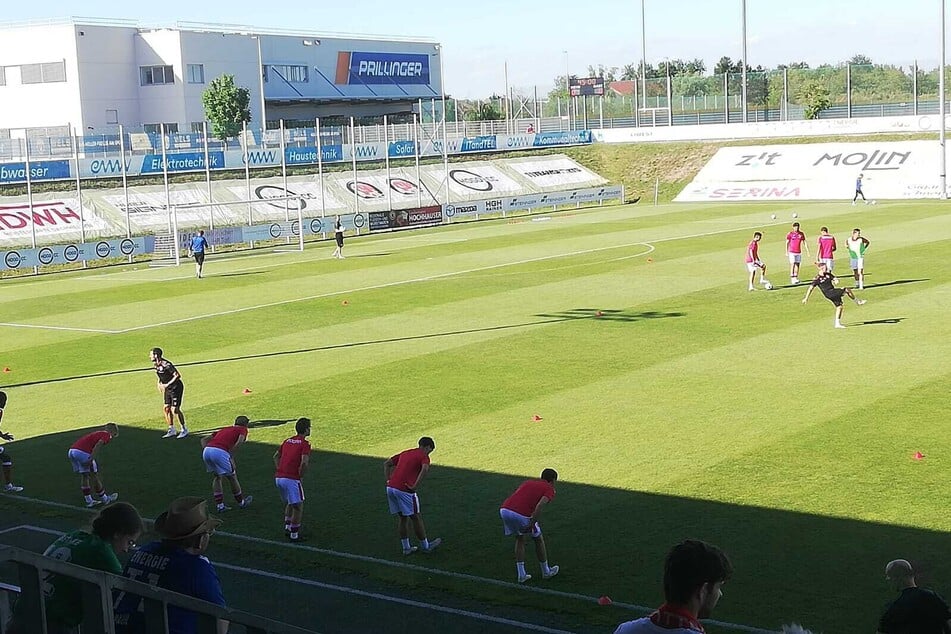 Die Aufwärmung hat begonnen. Schatten gibt es nur auf Seite der Tribüne.