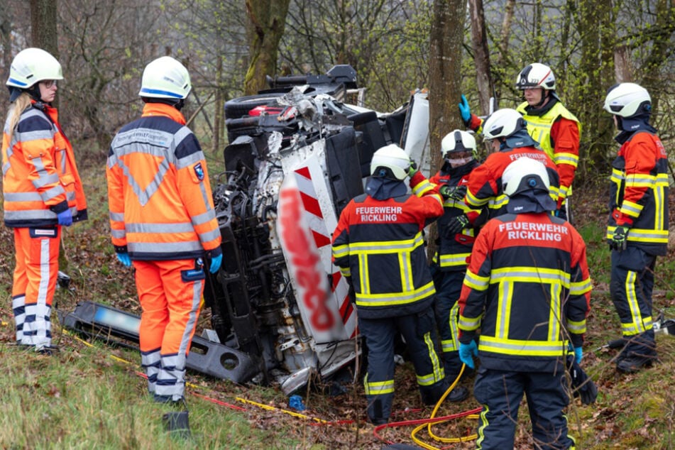 Der Lkw samt Arbeitsbühne kam von der Fahrbahn ab, krachte gegen mehrere Bäume und blieb auf der Seite liegen.