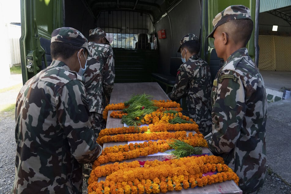 Armeeangehörige tragen einen Sarg mit der Leiche eines nepalesischen Staatsangehörigen am internationalen Flughafen Kathmandu.