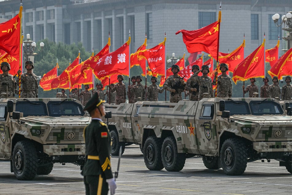 Members of the Chinese military hold flags during a military parade marking the 80th anniversary of victory over Japan and the end of World War II, in Beijing’s Tiananmen Square on September 3, 2025.