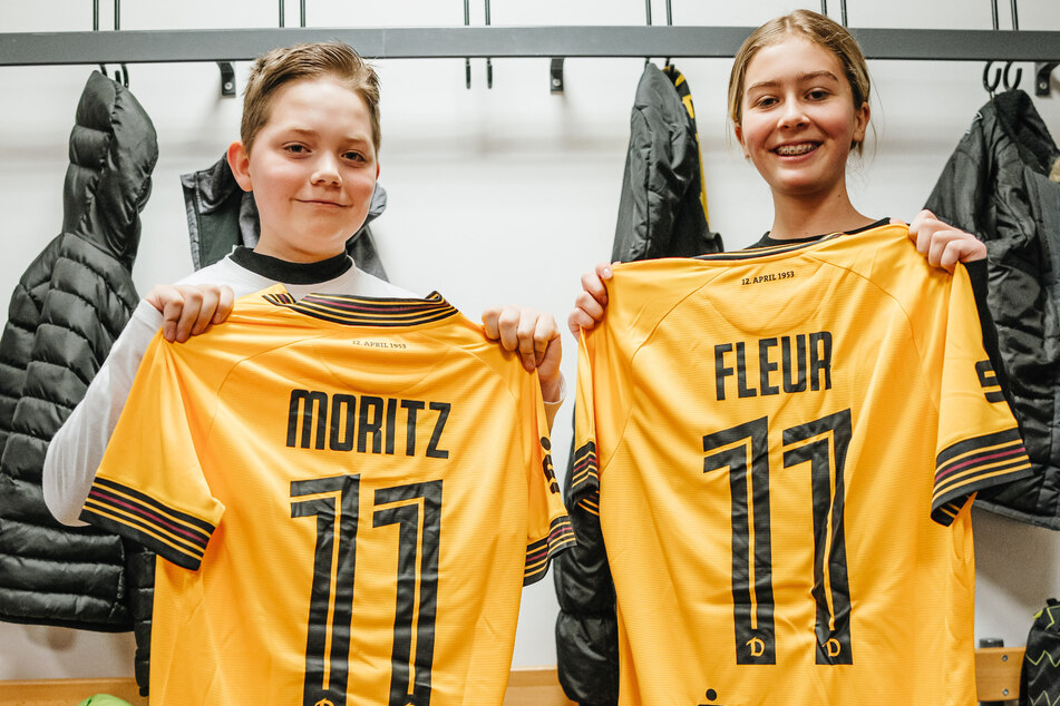 Moritz (11) und Fleur (11) zeigen stolz die Trikots mit ihren Namen, die sie mit nach Hause nehmen dürfen.