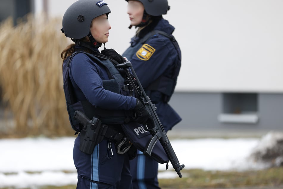 Auch die Polizei steht vor dem Schulgebäude mit Waffen.