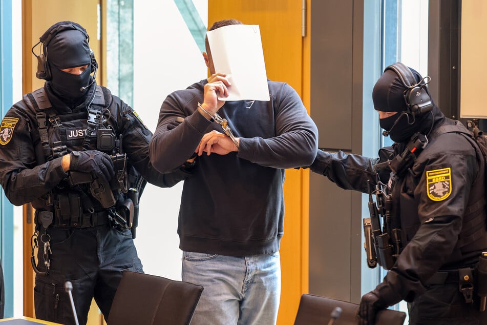 Der 29-Jährige trug beim Erscheinen Hand- und Fußfesseln.