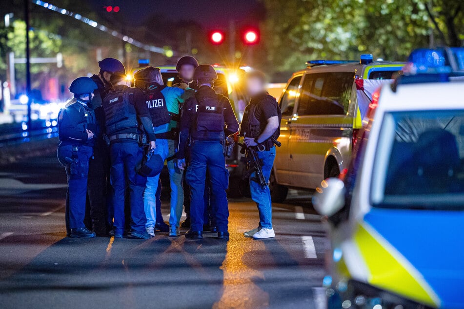 Einsatzkräfte steckten beratend die Köpfe zusammen. Die Schießerei forderte mindestens einen Toten.
