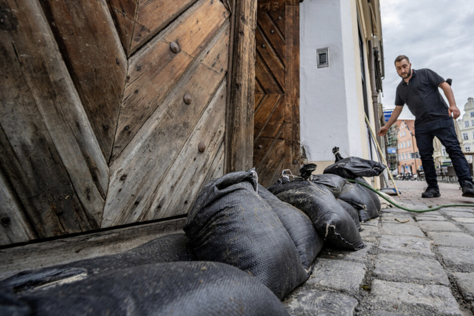 Sandsäcke liegen vor einem Café in Landshut. Die Stadt in Niederbayern war besonders von starken Regenfällen betroffen.