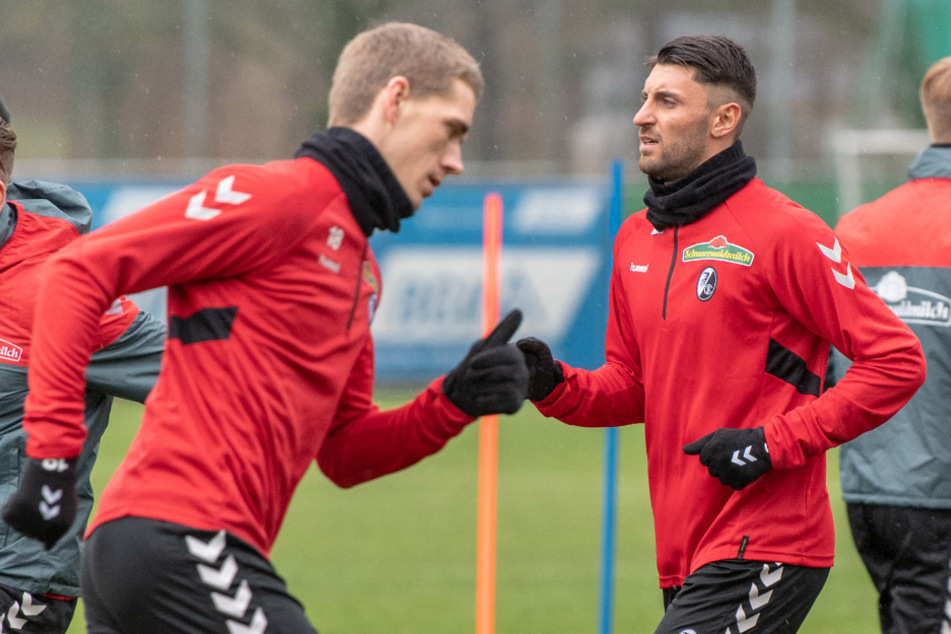 Vincenzo Grifo vom SC Freiburg (r) rennt mit Nils Petersen (l) beim Training über den Platz.