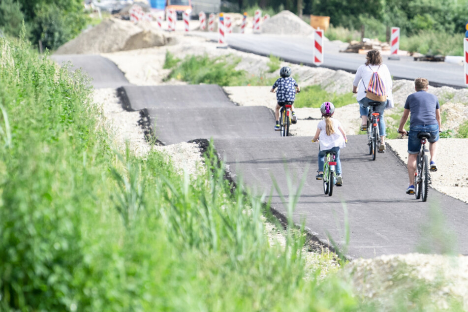Ein als Buckelpiste angelegter Radweg ist neben einer glatt asphaltierten Straße zu sehen.