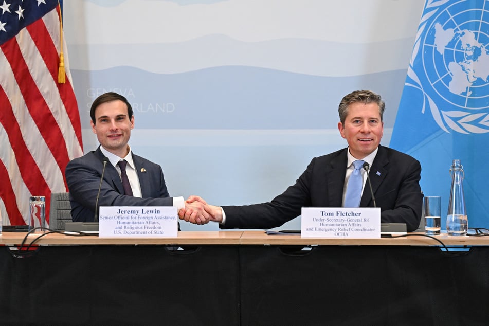 US Under Secretary of State for Foreign Assistance, Humanitarian Affairs and Religious Freedom Jeremy Lewin (L) shakes hands with UN Under-Secretary-General for Humanitarian Affairs Tom Fletcher during the signing ceremony of a $2 billion pledge of US for UN humanitarian aid in 2026, at the US Mission in Geneva, on Monday.