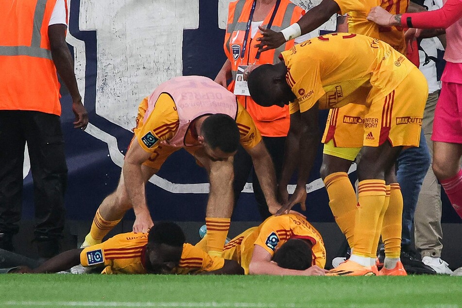 Der französische Mittelfeldspieler Lucas Buades (M.) von Rodez liegt auf dem Boden, nachdem er von einem Fan attackiert wurde.