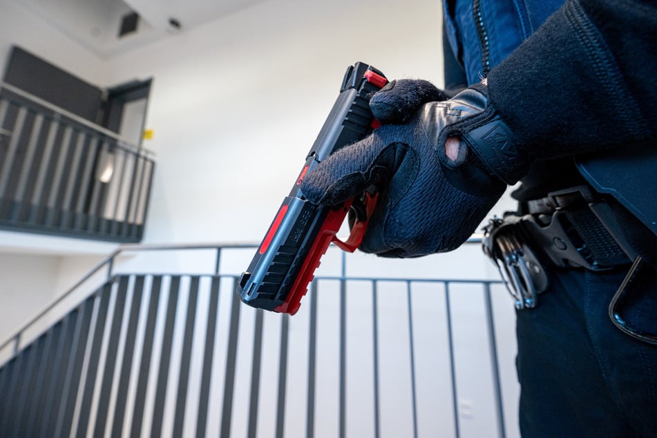 Ein Polizist hält in einem Trainingszentrum eine Übungs-Pistole.