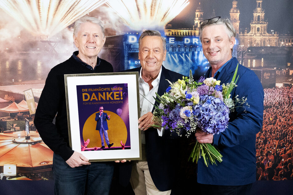 Die Filmnächte-Chefs Johannes Vittinghoff (l.) und Matthias Pfitzner (r.) gratulieren Schlagerstar Roland Kaiser mit Blumen und dem Filmnächte-Award.