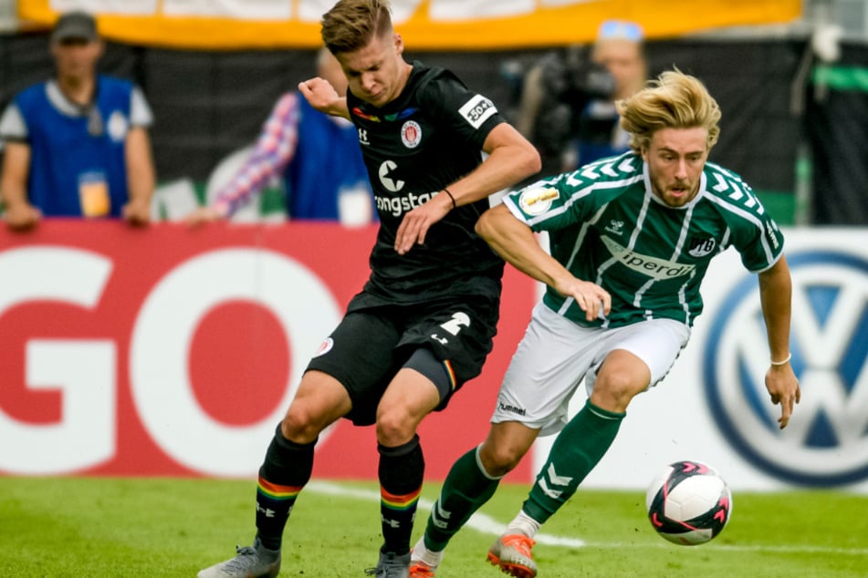 St. Paulis Jakub Bednarczyk (l.) und Lübecks Marcel Schelle kämpfen um den Ball.