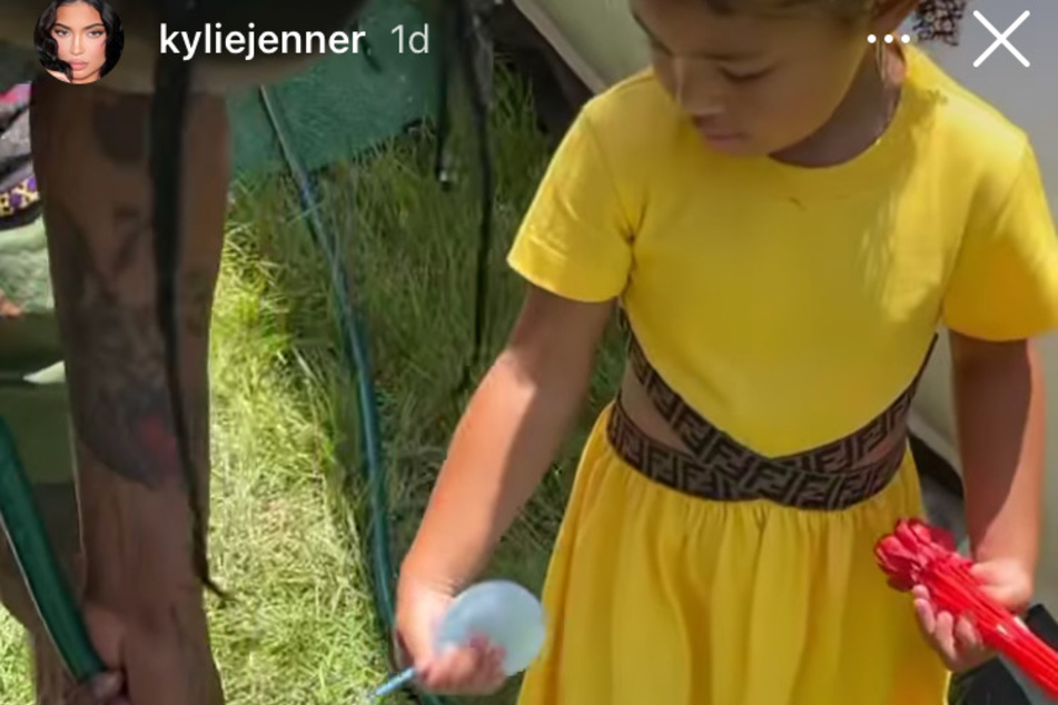 Daddy's girl! Stormi Webster helps her dad, Travis Scott, fill balloons with water.