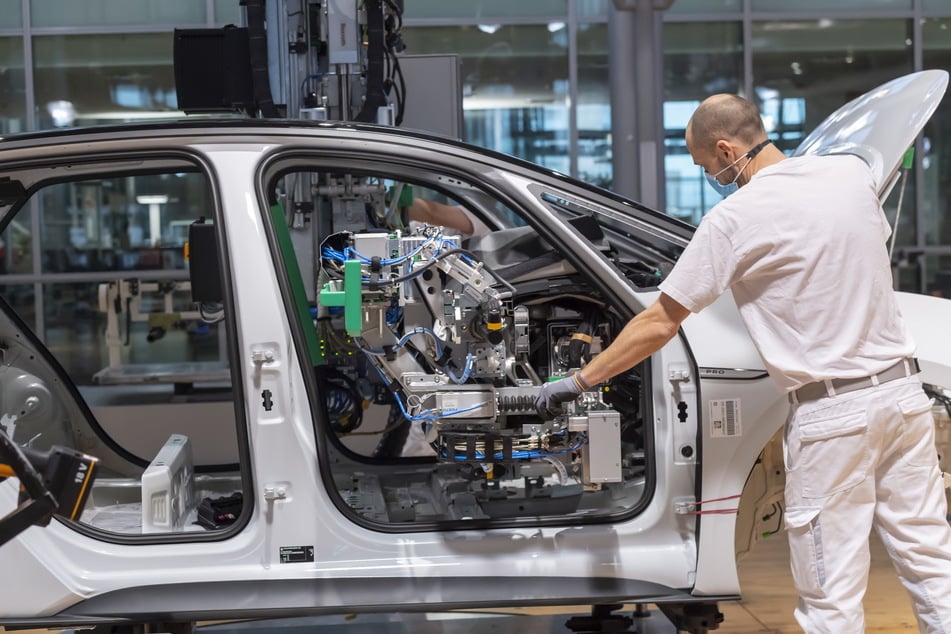 Ein VW-Mitarbeiter baut Teile für ein Elektroauto ein.