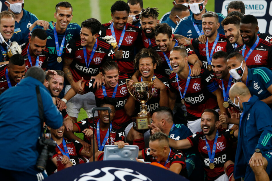 Die Spieler von Flamengo jubeln mit der Trophäe über den Gewinn der Meisterschaft. Rafinha (vorne in der Mitte) spielte den Getränkewart.