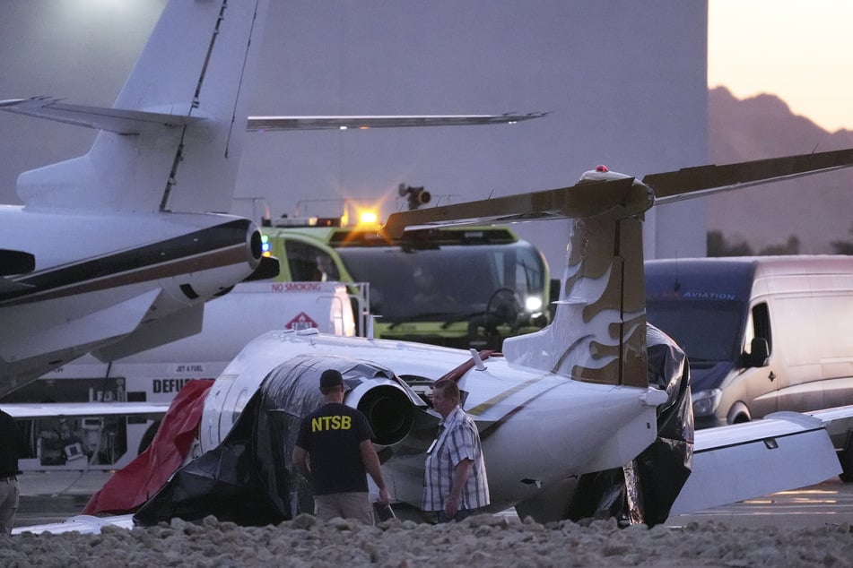 Ermittler untersuchen den abgestürzten Learjet auf dem Scottsdale Airport, nachdem er mit einem geparkten Flugzeug kollidiert war.