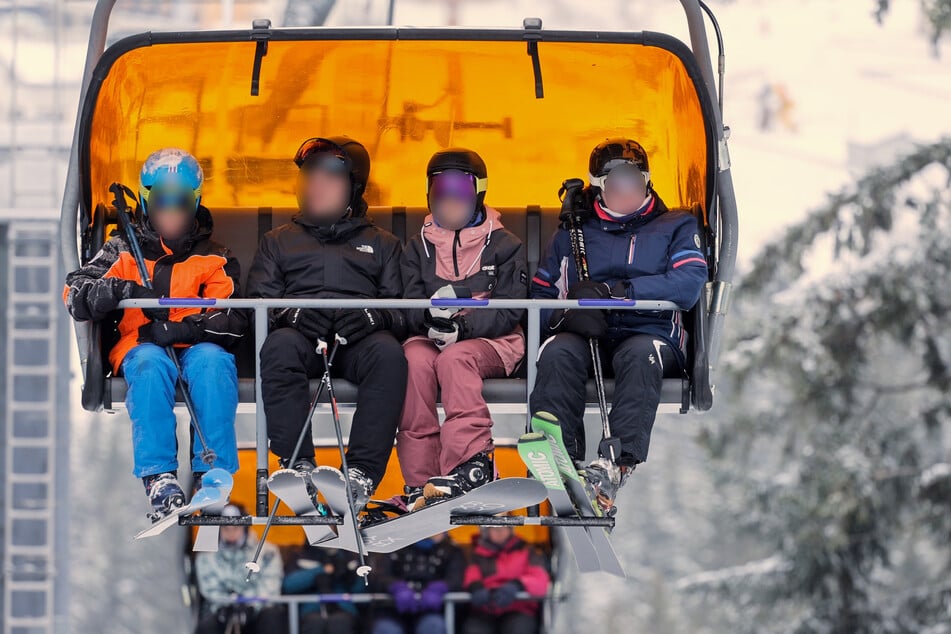 Skifahrer im Sessellift auf dem Weg zum Gipfel des Keilbergs - hier sind aktuell 15 von 32 Pisten geöffnet.