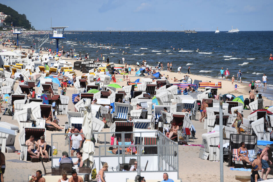 Touristen genießen die hochsommerlichen Temperaturen am Timmendorfer Strand.