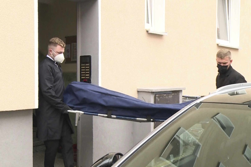 Bestatter tragen die 53-jährige, ermordete Frau aus ihrer Wohnung.