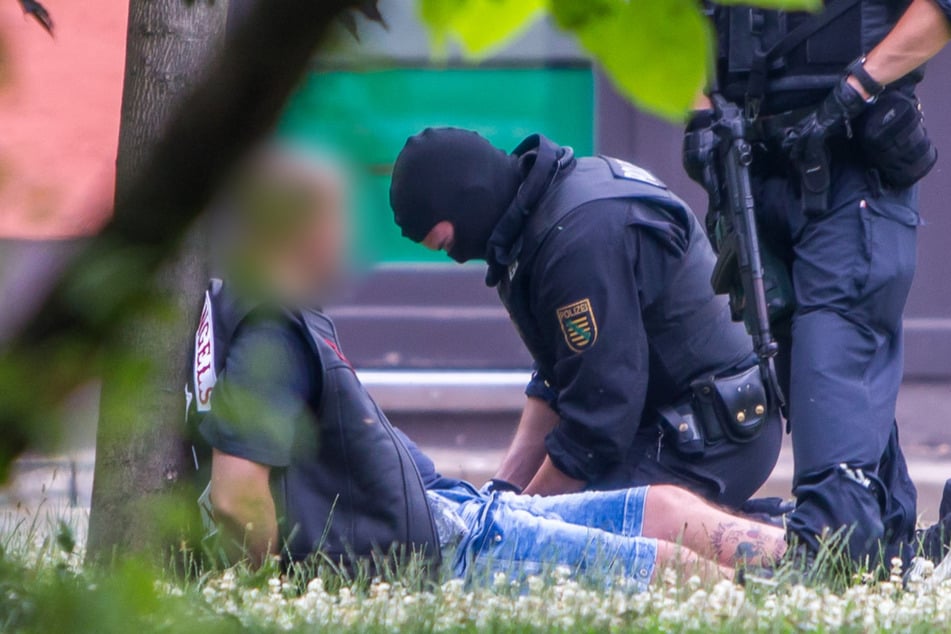 Schwer bewaffnete Polizisten nehmen nach der Auseinandersetzung Rocker der Hells Angels fest.