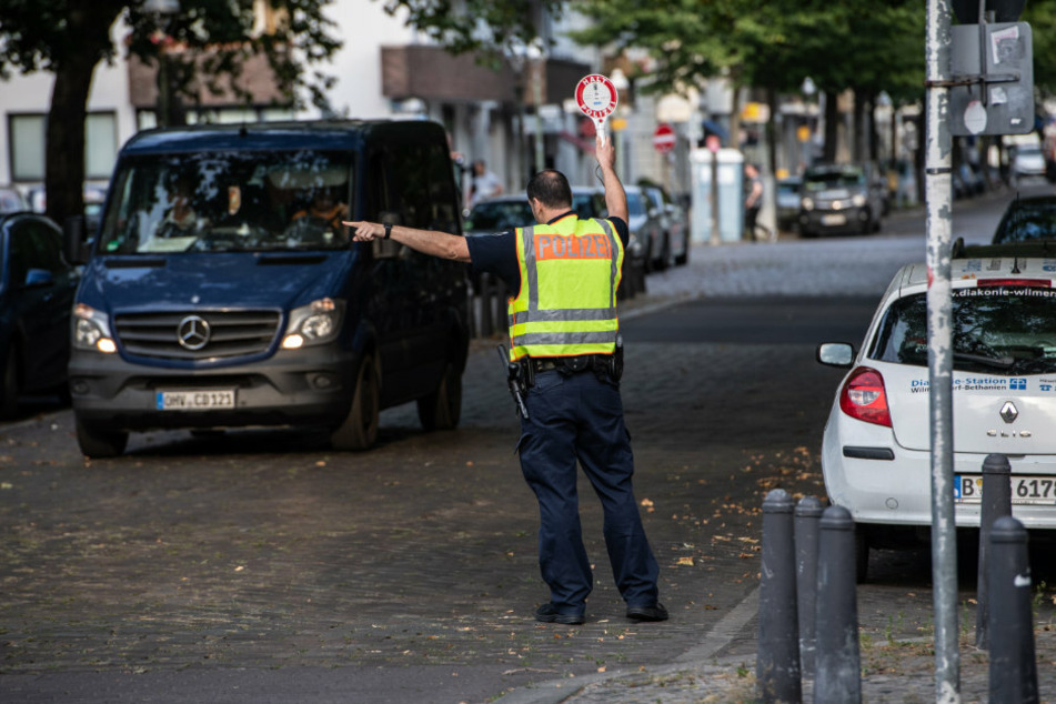 Ein Polizeibeamter winkt bei einer Verkehrskontrolle in Berlin ein Fahrzeug aus dem Verkehr.