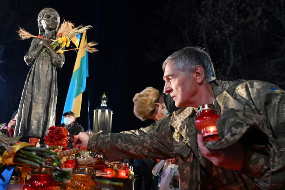 Im November 2021 zünden Menschen in Kiew während einer Gedenkzeremonie an einem Denkmal für die Opfer der Holodomor-Hungersnot von 1932 und 1933 Kerzen an.
