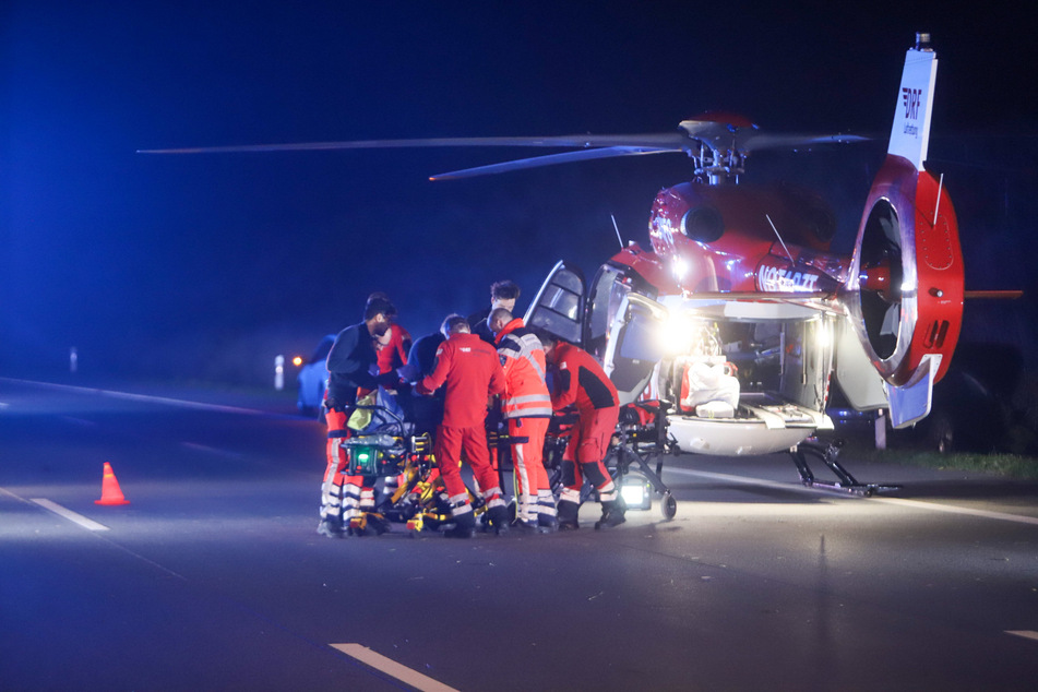 Rettungskräfte verladen eine verletzte Person nach dem Unfall auf der A7 in einen Hubschrauber.
