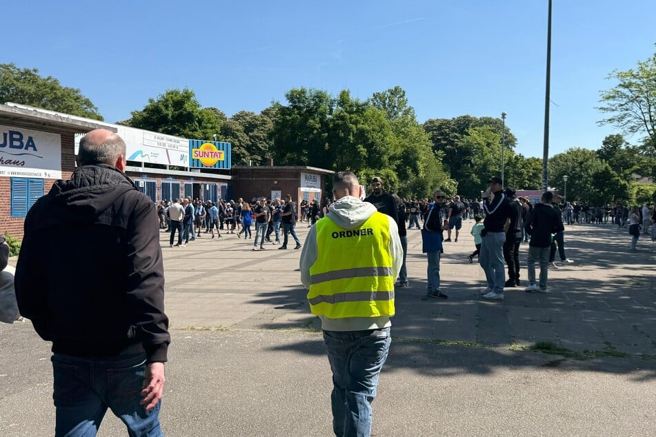 Ein Ordner führt Dynamo-Mitarbeiter und Presse zum Stadion.