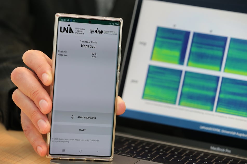 Björn Schuller, Leiter der Studie Spracherkennungs-App für Corona-Infizierte, zeigt an der alten Universität auf einem Smartphone das negative Ergebnis eines Corona-Tests per Spracherkennung.