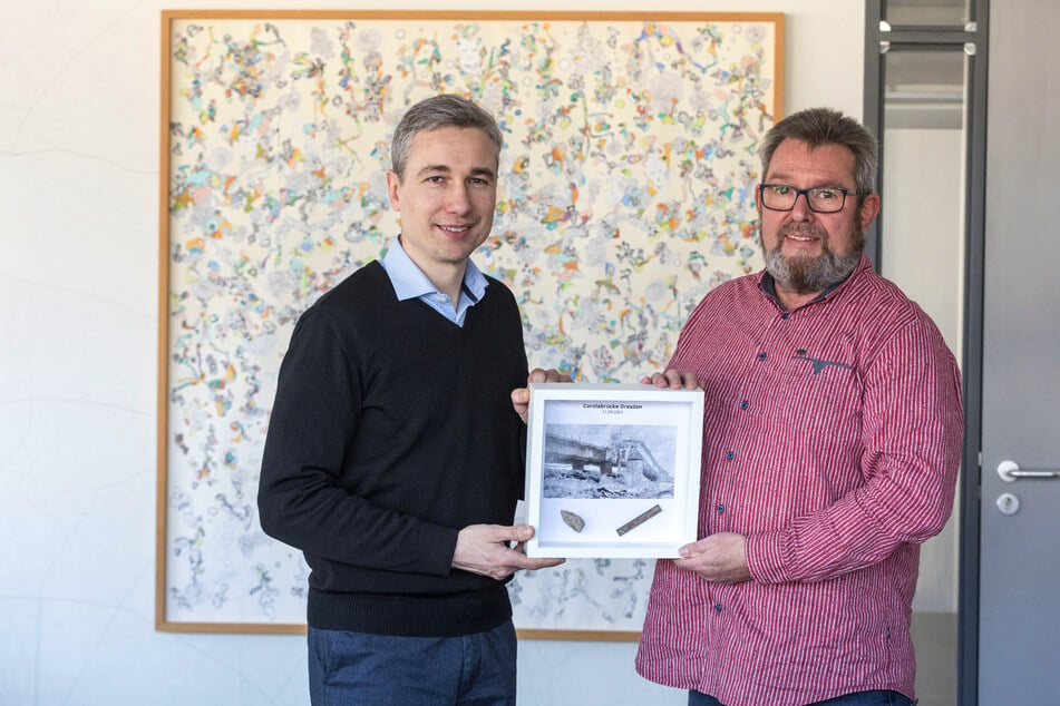 Torsten Meisel (59, r.) übergibt das "Carolabrücken-Kunstwerk" mit der Nummer 001 an Baubürgermeister Stephan Kühn (45, l.).