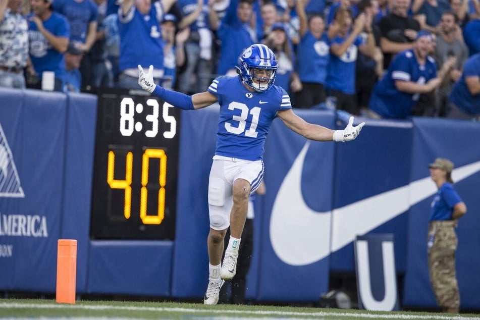 Max Tooley of the Brigham Young Cougars celebrates scoring a touchdown on an interception against the Utah State Aggies