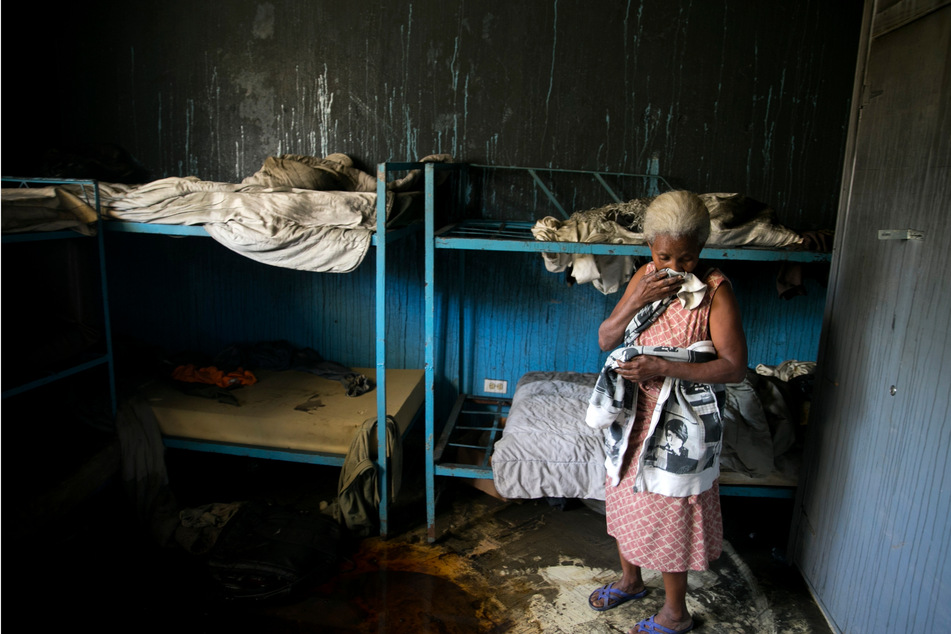 Eine Mitarbeiterin des Waisenhauses der Church of Bible Undertanding steht in einem Schlafzimmer, welches von einem Feuer zerstört wurde.