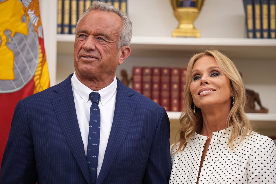 Robert F. Kennedy Jr. (l.) and his wife, Cheryl Hines, listen as President Donald Trump speaks before Kennedy is sworn in as Secretary of Health and Human Services in the Oval Office of the White House on February 13, 2025.
