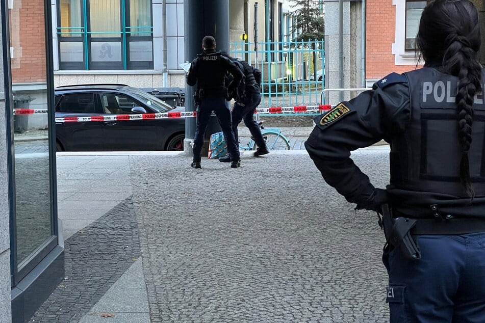 Polizisten durchsuchen einen Einkaufsbeutel.