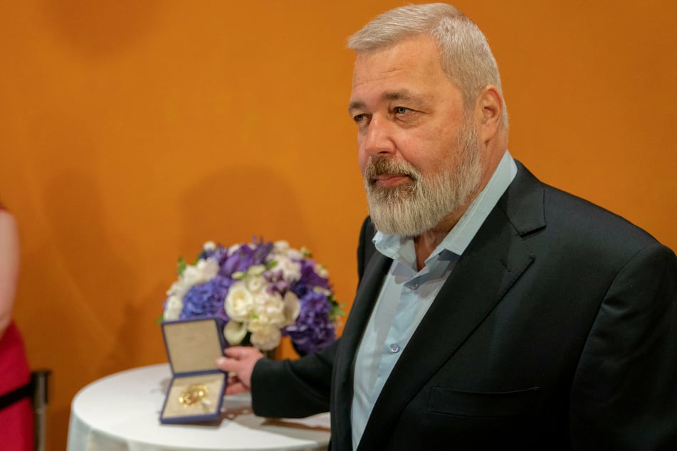 Russian journalist Dmitry Muratov holds his Nobel Peace Prize medal, which he auctioned off for humanitarian funds.