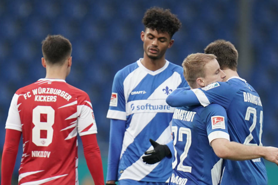 Darmstadts Immanuel Höhn (r-l), Fabian Holland und Tim Skarke jubeln nach dem 2:0, Würzburgs Vladimir Nikolov ist enttäuscht.