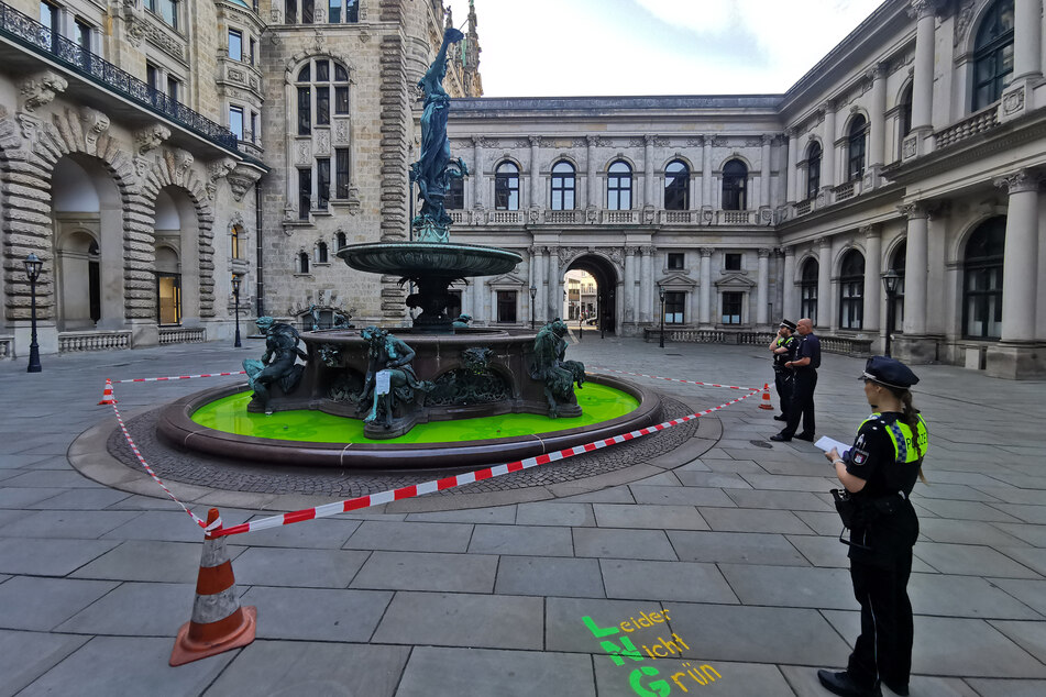 Die Polizei sichert den Brunnen im Innenhof des Rathauses, nachdem Aktivisten von Extinction Rebellion eine grüne Flüssigkeit in das Wasser geschüttet hatten.