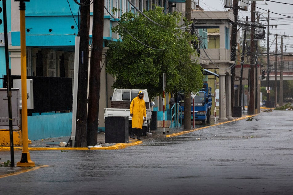 A man looks at a flooded street in Kingston, Jamaica, as Hurricane Beryl hits the southern coast of the island.
