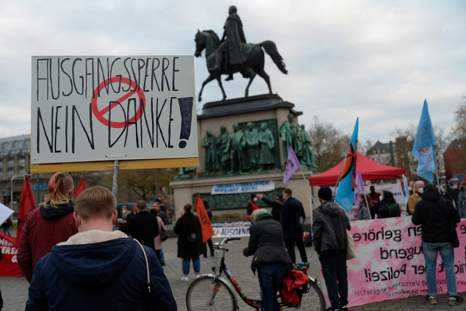 Ein Teilnehmer trägt bei einer Demonstration gegen Ausgangsbeschränkungen in Köln ein Plakat mit der Aufschrift "Ausgangssperre nein Danke".