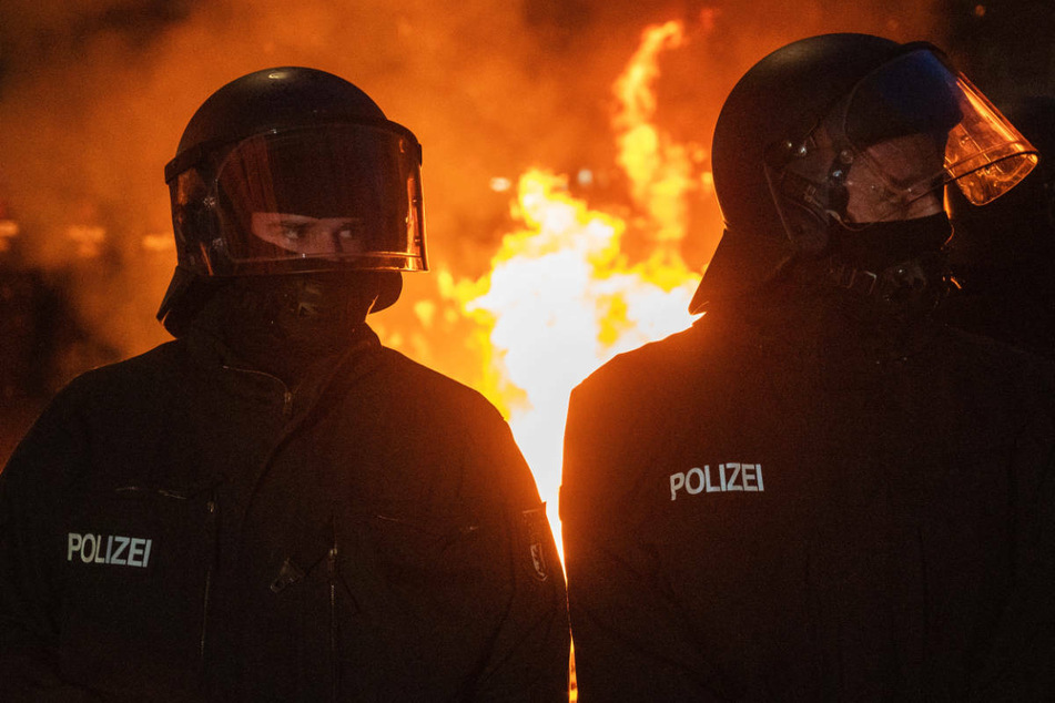 Polizisten stehen vor einem Feuer am Rande des Demonstrationszugs linker und linksradikaler Gruppen unter dem Motto "Demonstration zum revolutionären 1. Mai". Die Gewerkschaft der Polizei geht in diesem Zusammenhang von 50 verletzten Polizisten und über 250 Festnahmen aus.