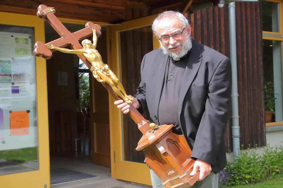 Pfarrer Stefan Schwarzenberg (59) zeigt das Kreuz, das aus der Sakristei noch gerettet werden konnte.