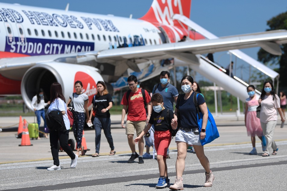 Passagiere tragen Mundschutz am Malaysischen Flughafen "Sultan Azlan Shah Airport".