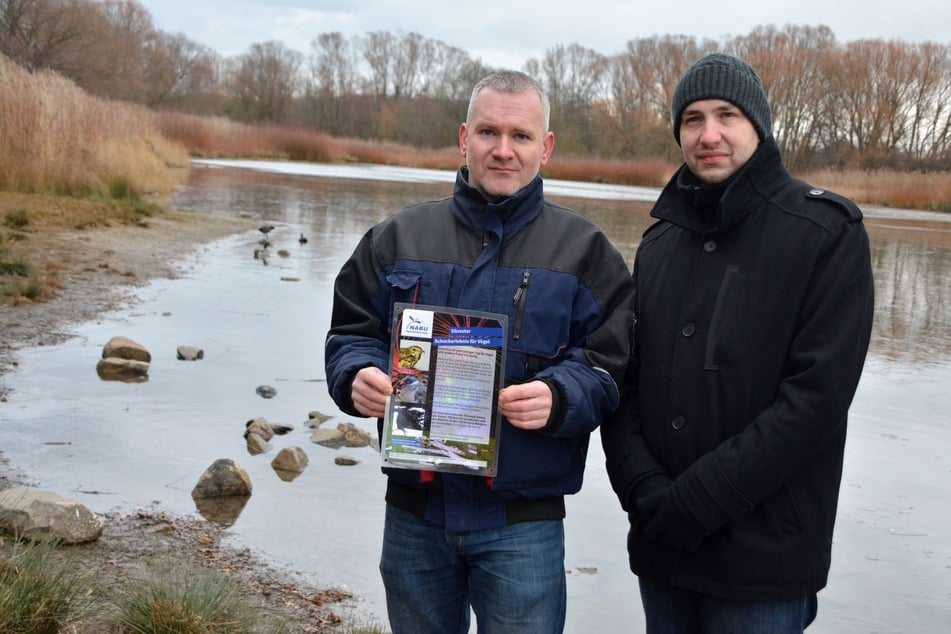 Karsten (44) und Tobias Peterlein (35) haben auch am Leipziger Silbersee Warnhinweise angebracht.