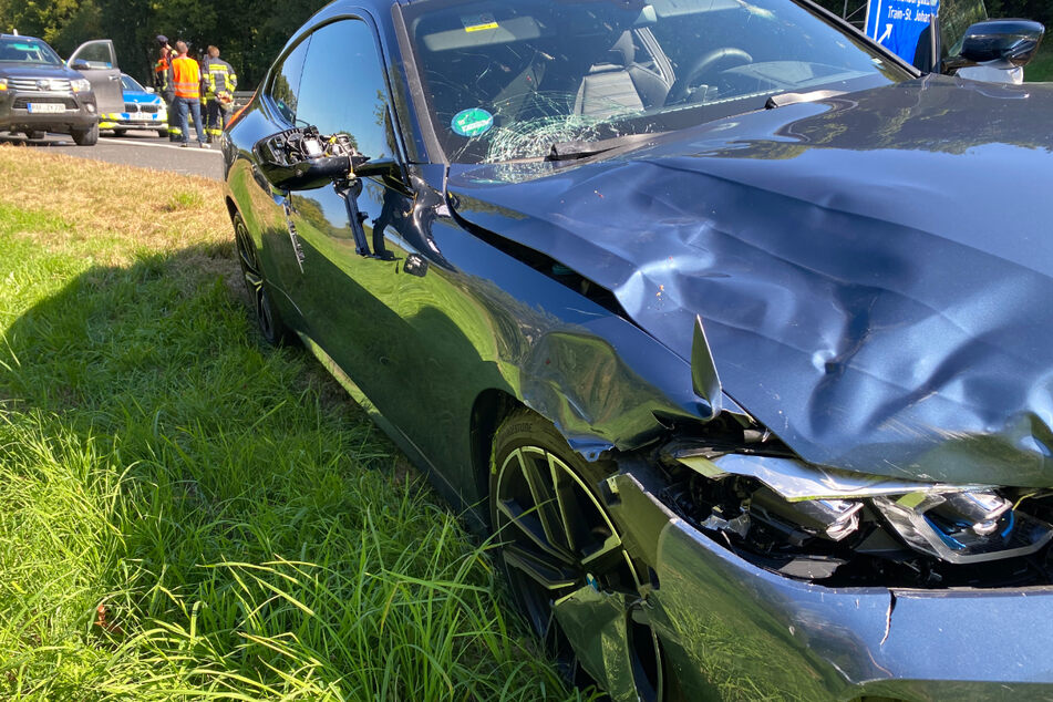 Der verbeulte BMW steht am Unfallort am Fahrbahnrand der A93.