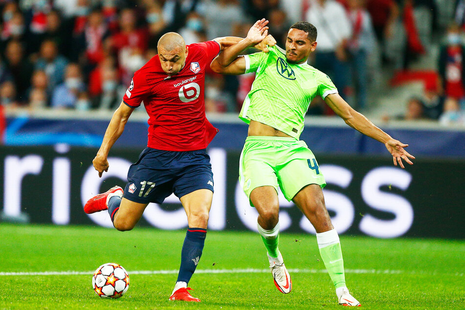 VfL Wolfsburgs Maxence Lacroix (r.) gegen Burak Yilmaz vom OSC Lille.