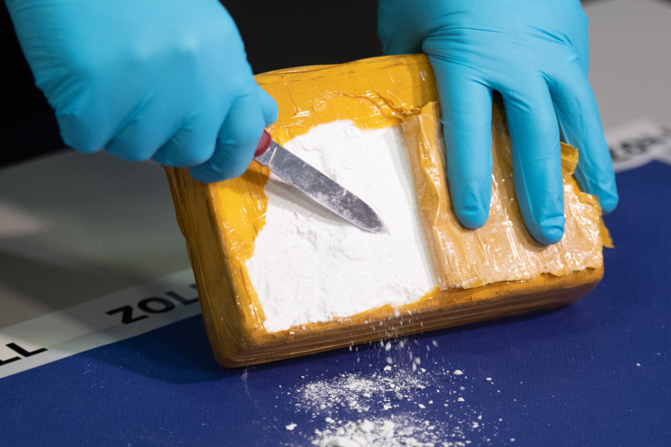 Ein Zollbeamter öffnet während einer Pressekonferenz ein Paket mit Kokain, das von den Beamten im Hamburger Hafen sichergestellt wurde. (Symbolbild)