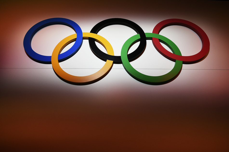 Die Olympischen Ringe hängen an einer Wand. Die Tests für die Winterspiele 2022 seien nicht in Gefahr.