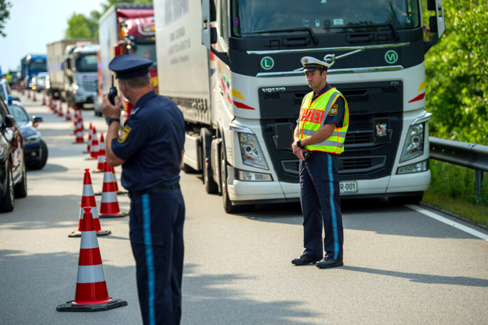 Ein Polizeibeamter stoppt zu Beginn der Grenzkontrollen durch die bayerische Landespolizei am Grenzübergang Kirchdorf den Verkehr.