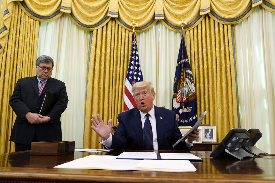 William Barr (l), Justizminister der USA, hört Erläuterungen von Donald Trump (M.), Präsident von USA, an, bevor der Staatschef im Oval Office des Weißen Hauses eine Verfügung gegen den rechtlichen Schutz sozialer Netzwerke unterschreibt.