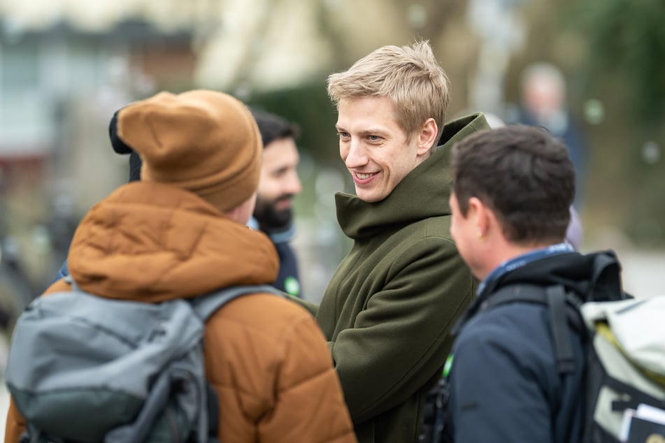 Dominik Krause (35, Grüne) spricht an einem Wahlkampfstand mit Bürgern.